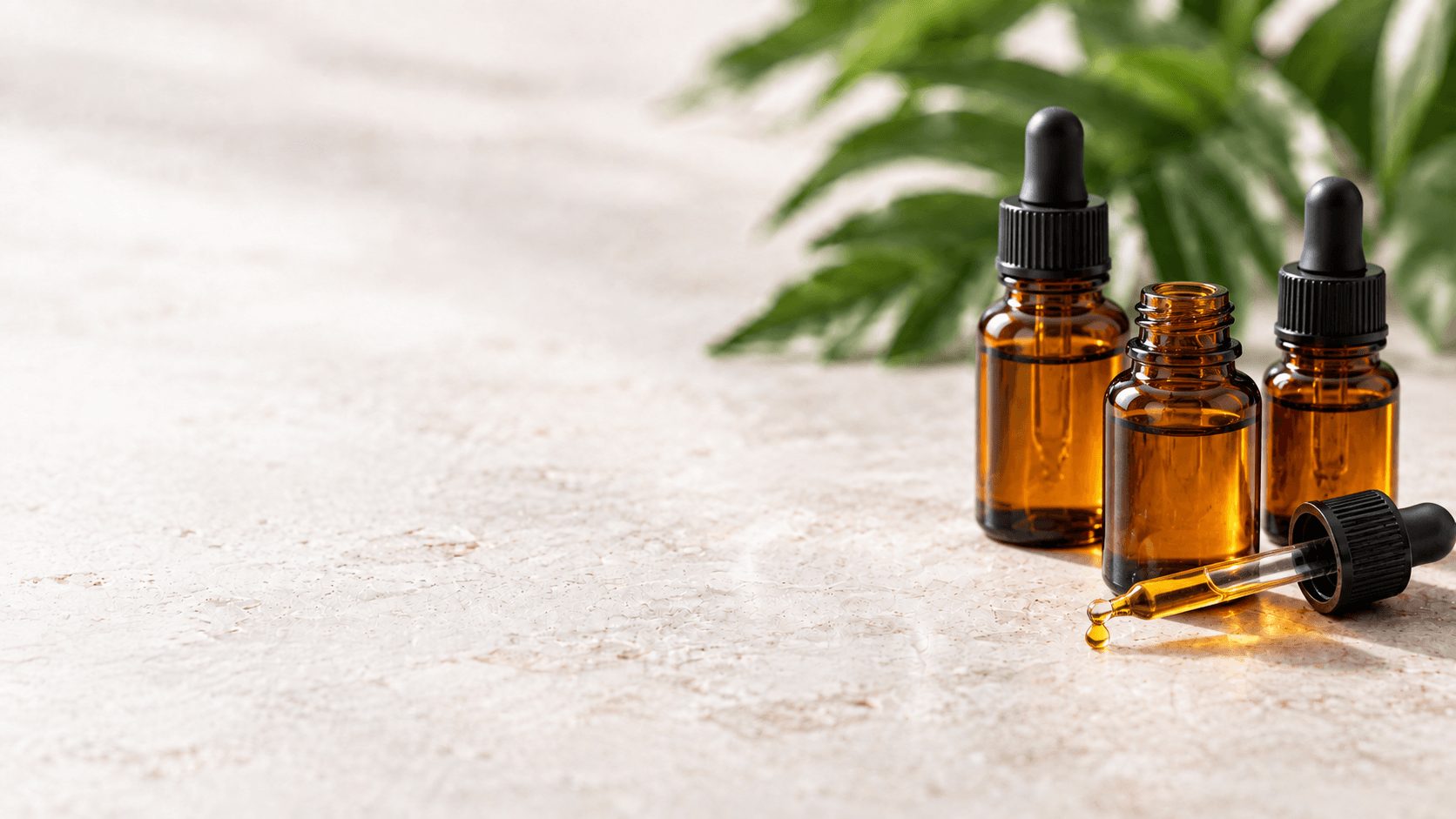 Amber glass supplement dropper bottles on a stone tabletop